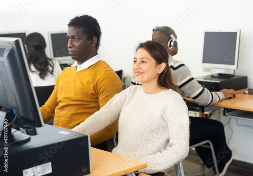 Portrait of interested young adults of different nationalities studying in university computer class
