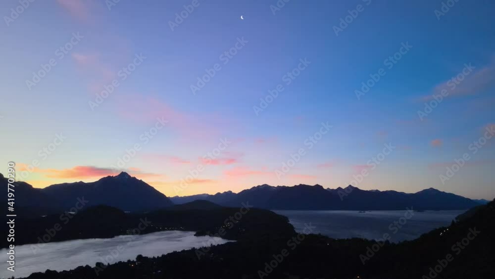 Pan shot of the meeting between the sunset and the crescent moon over the Nahuel Huapi lake as the stage. Patagonia, Argentina. Aerial Footage Pan shot of the meeting between the sunset and the crescent moon over the Nahuel Huapi lake as the stage. Patagonia, Argentina. Aerial Footage