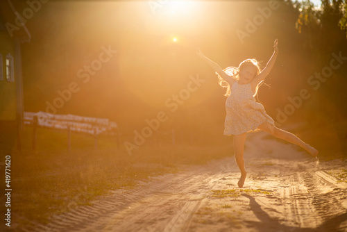 blonde girl runs on the sand at sunset, selective focus © Ekaterina