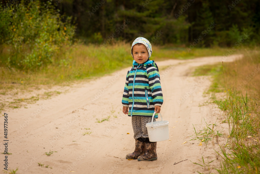 3-year-old boy walks on a village road, selective focus 3-year-old boy walks on a village road, selective focus