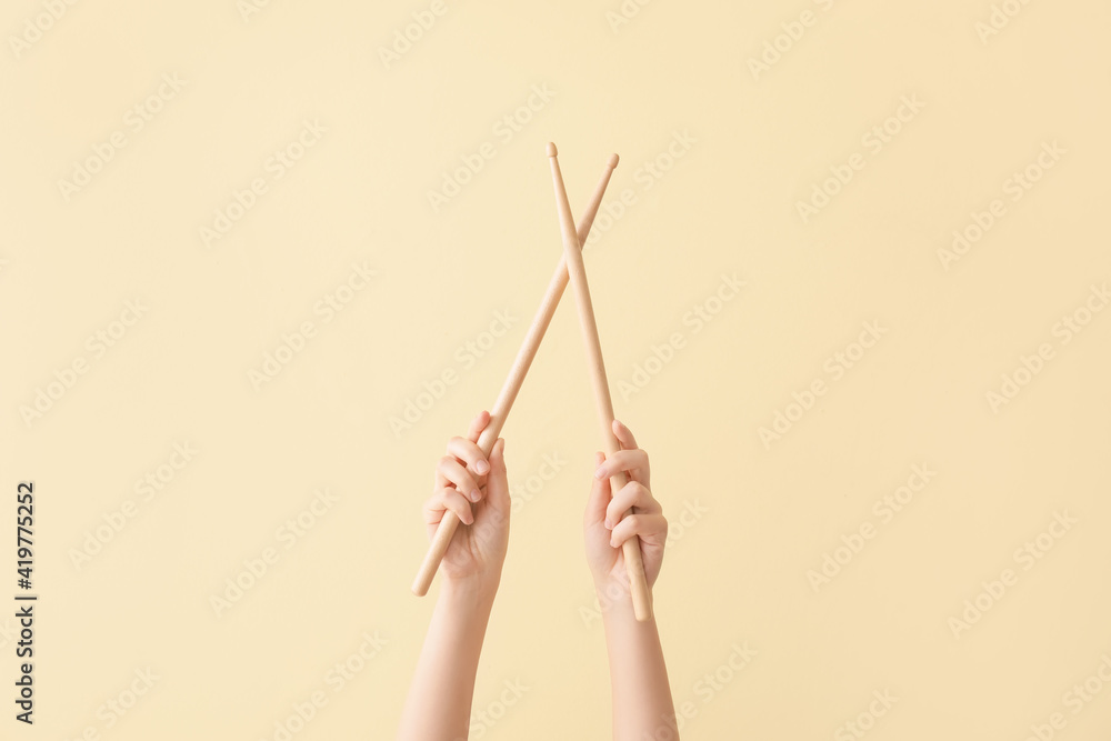 Woman holding wooden drumsticks on color background Woman holding wooden drumsticks on color background