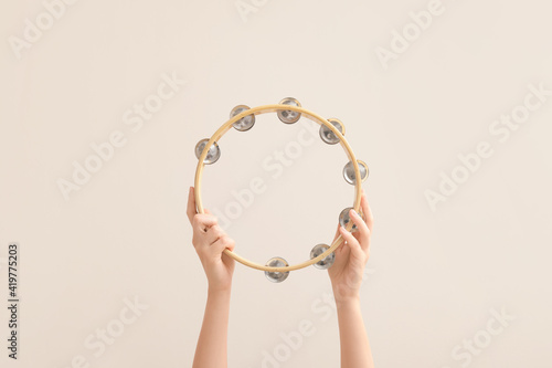 Photo Woman holding tambourine on color background