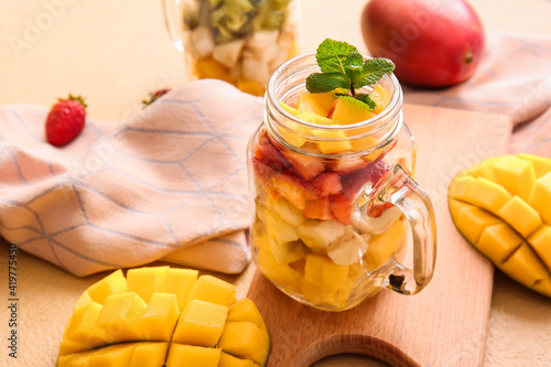 Fototapeta Naklejka Na Ścianę i Meble -  Mason jar with tropical fruit salad on color background