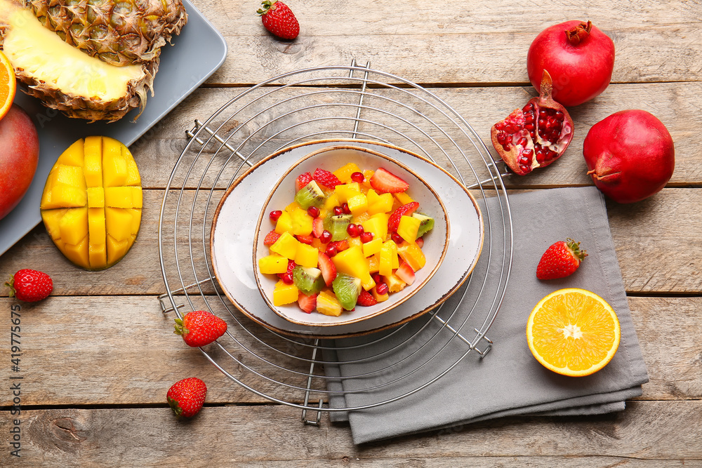 Bowl with tropical fruit salad on wooden background Bowl with tropical fruit salad on wooden background