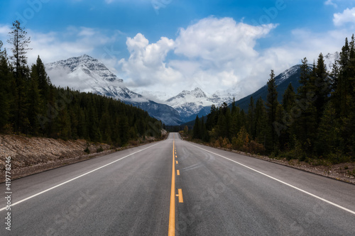 Scenic road in the Canadian Rockies during a vibrant sunny and cloudy summer morning. Artistic Render. Taken in Icefields Parkway, Banff National Park, Alberta, Canada.