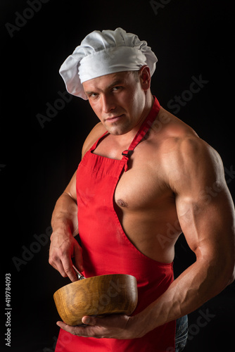 Man chef at kitchen with pestle and mortar. Sexy cuisine guy cooking condiments. photo