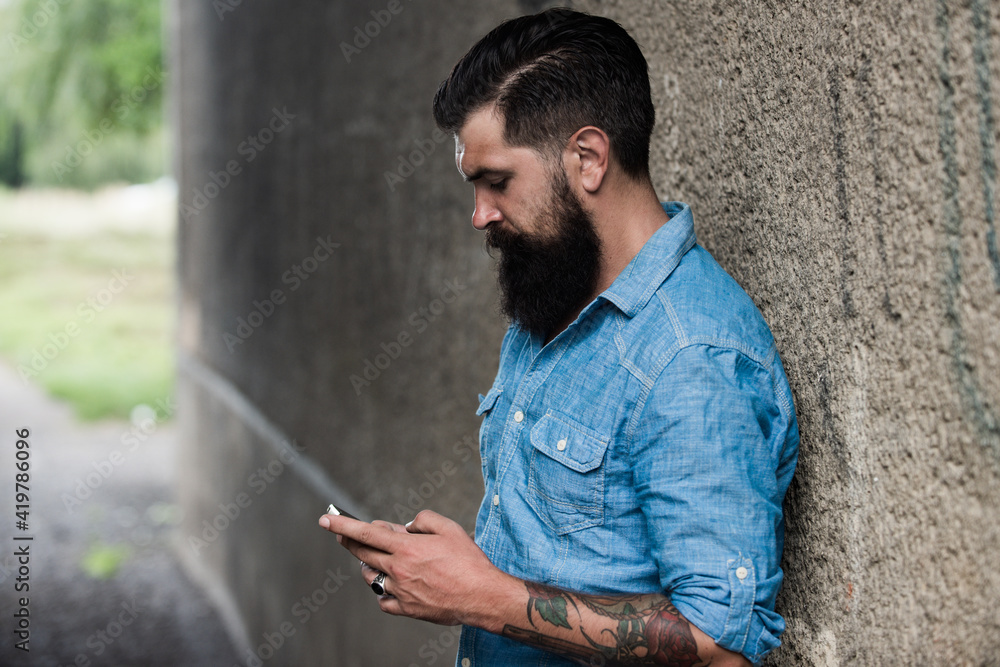 Obraz premium Young business man with smartphone on street. Talking on mobile phone. Smiling man with phone in the city. Businessman male.