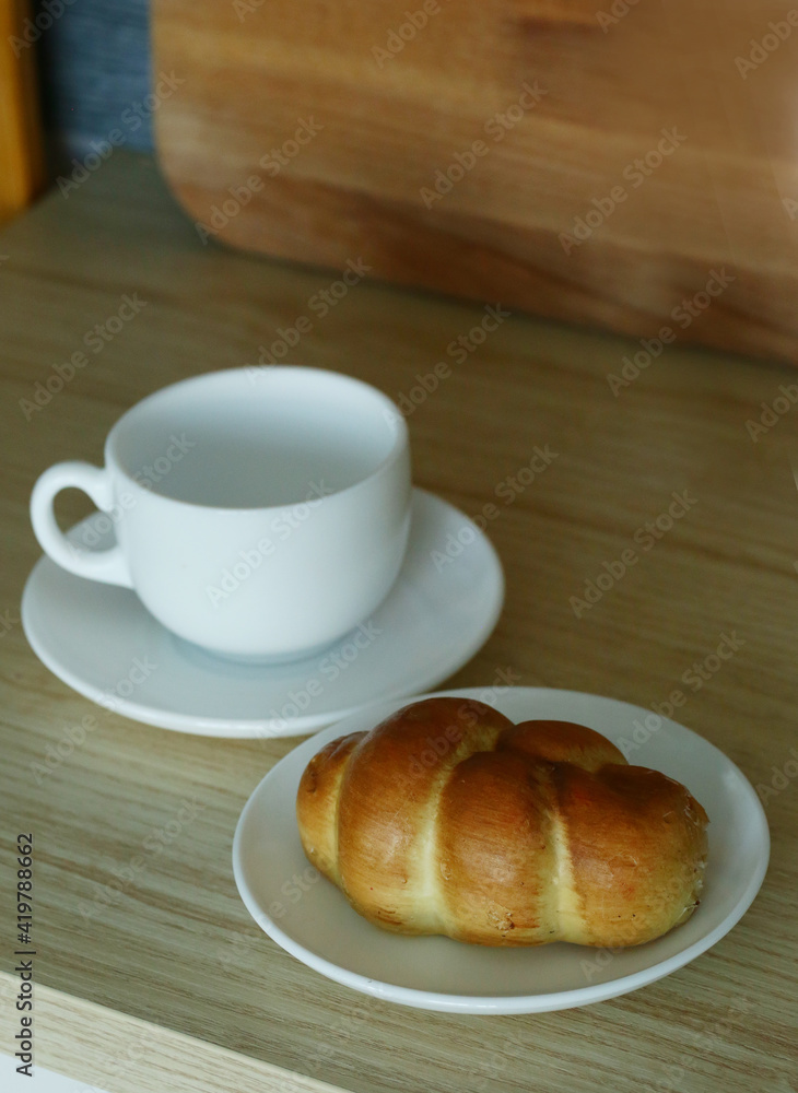 kitchen closeup fragment with croissant and tea cup on table kitchen closeup fragment with croissant and tea cup on table