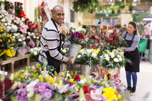 Florist man in apron creates bouquets in flower shop © JackF