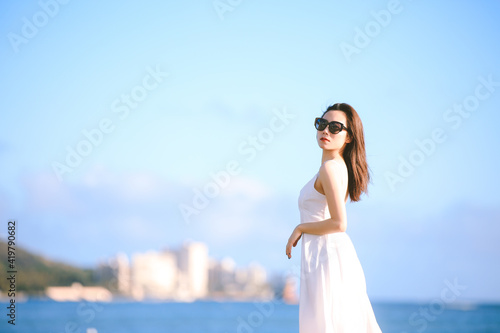 Girl wearing white long dress by the sea, Honolulu, Oahu, Hawaii © youli