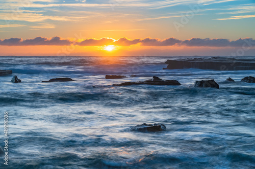 Sunrise seascape in the rocky alcove © Merrillie