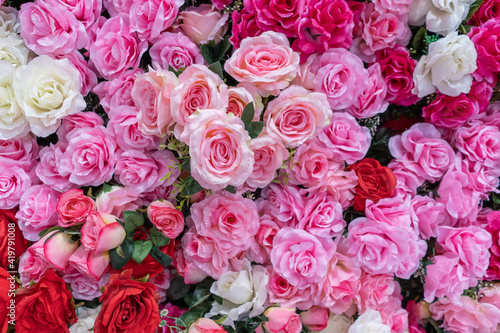 Background of artificial roses of different colors  pink reds white roses