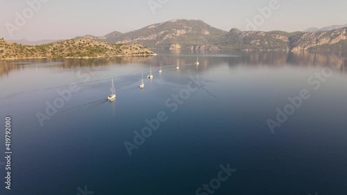 Sailboats Flotilla Drifting On Calm Water Between Islands 
 photo