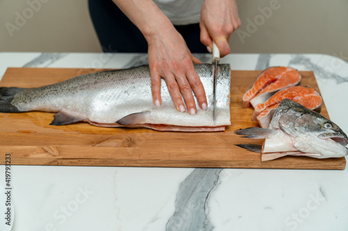slicing steaks from a carcass of a red fish