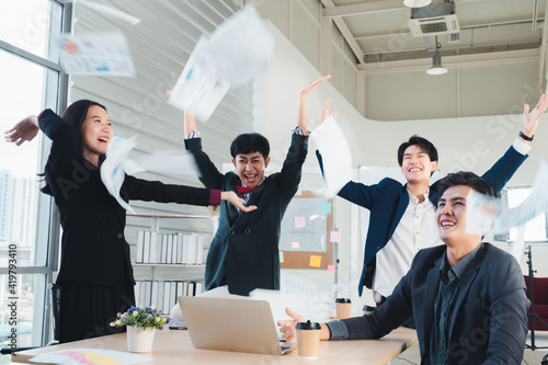 Team of LGBT business people throws paper in joy of meeting their goals, achievements, achievements. LGBTQ business team concept, jumping to celebrate Asian ethnic success.