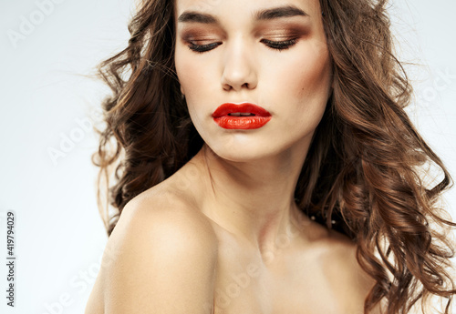 Charming lady with closed eyes eyeshadows and bright makeup red lips