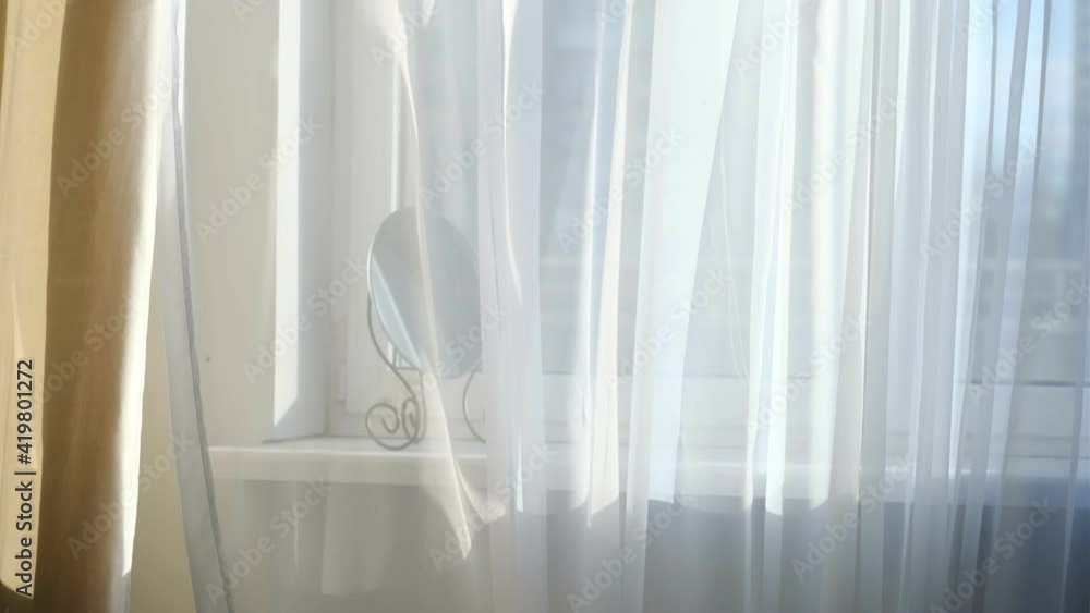 wind blows through the open window in the room. Waving white tulle near the window.