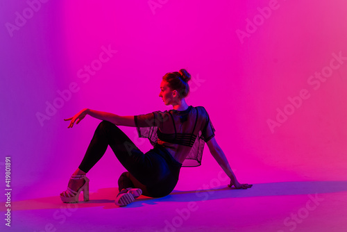 Fototapeta Naklejka Na Ścianę i Meble -  Beautiful young woman wearing sexy high heels and black clothes while dancing in pole dance studio