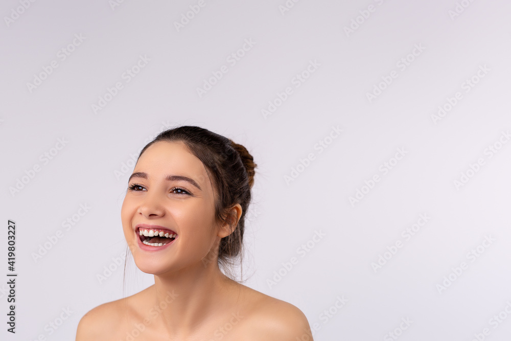 Profile of a beautiful, young, smiling, brunette with bare shoulders, who surprising, pleasant smile, ideal in the concept of promoting beauty and femininity. Profile of a beautiful, young, smiling, brunette with bare shoulders, who surprising, pleasant smile, ideal in the concept of promoting beauty and femininity.
