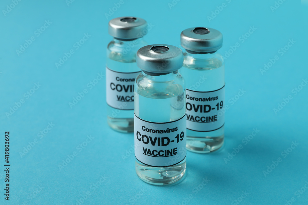 Vials of Covid - 19 vaccine on blue background Vials of Covid - 19 vaccine on blue background