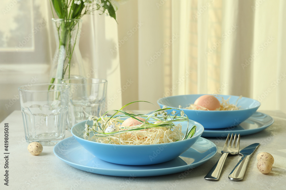 Happy Easter table setting with eggs on white textured table