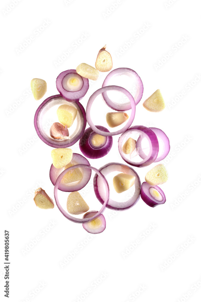 flying onion rings and sliced garlic cloves isolated on a white background flying onion rings and sliced garlic cloves isolated on a white background