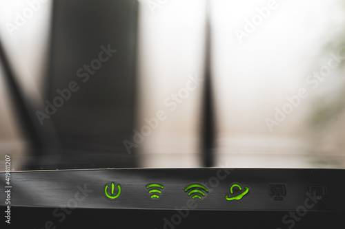 Close up shot of internet router and green icons of WIFI connection. Internet cable on router
