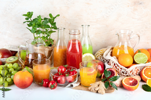 Healthy home made juices and fruits on light wooden background