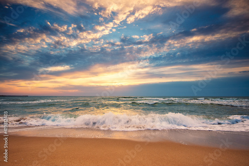 Beach sunrise over the sea and dramatic clouds © Gerisima