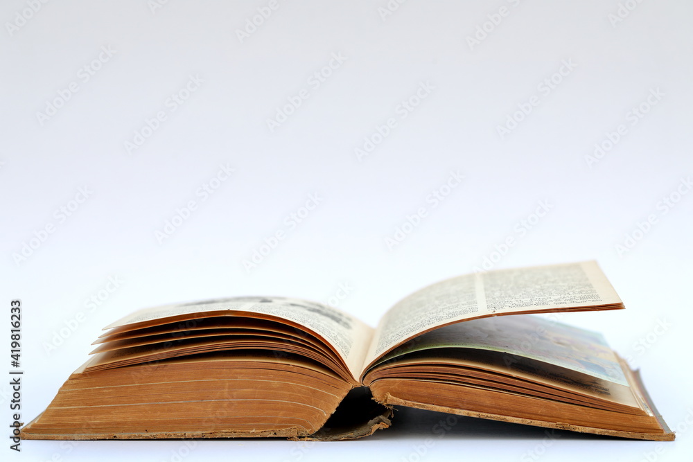 Open old book with text on white background