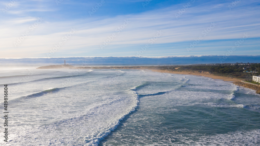 Aerial drone view of the Cape of Trafalgar with surfer waves breaking on the bay at the Atlantic Ocean in south Spain
