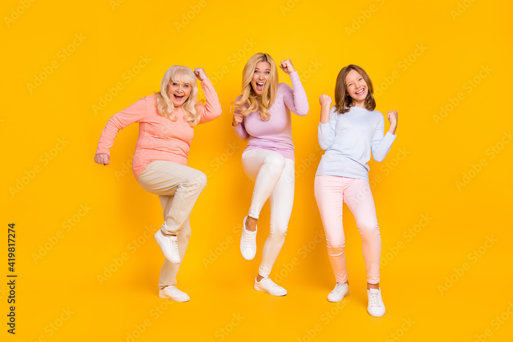 Obraz premium Photo of hooray three woman grand mom daughter hands fists wear pastel cloth isolated on yellow background