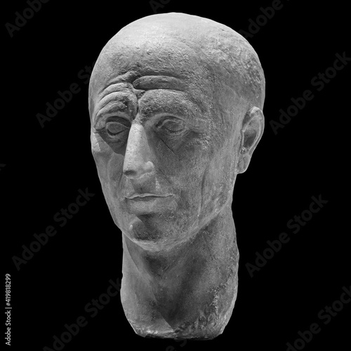 Head detail of the ancient man sculpture. Stone face isolated on black background. Antique marble statue of mythical character