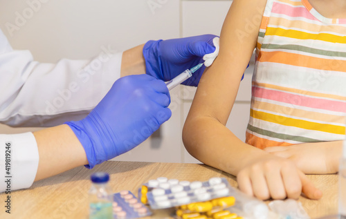 Injection vaccine against virus, injecting child. Selective focus