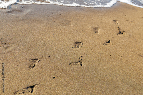 footprints in the sand. the baby left traces of bare feet by the sea.