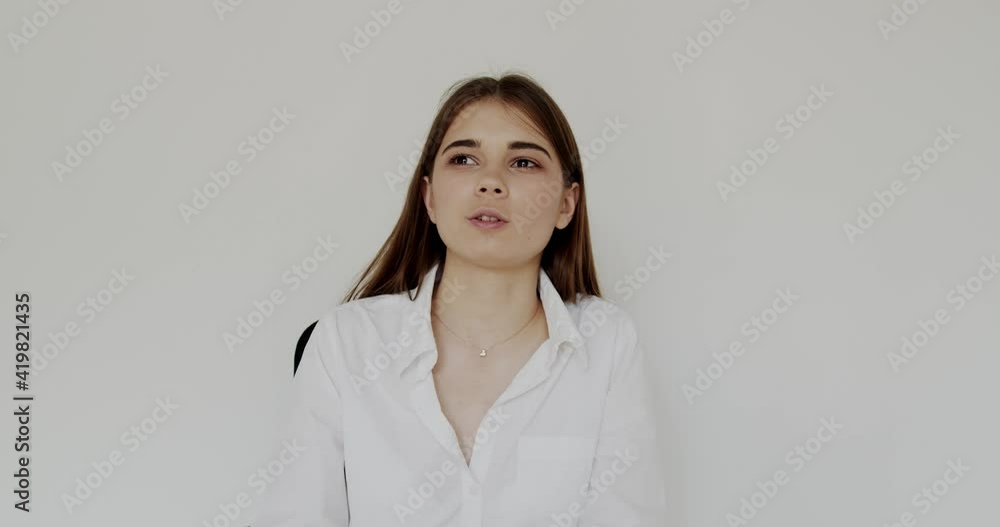 Portrait of young, happy girl talking and smiling at camera on background Portrait of young, happy girl talking and smiling at camera on background