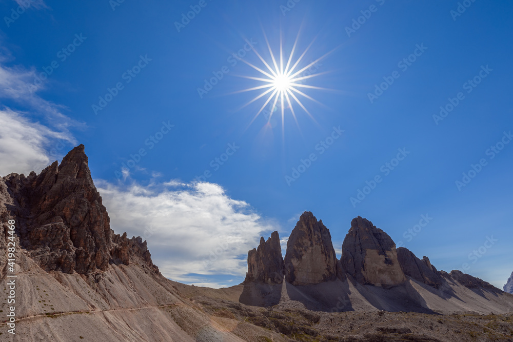 Tourist trail under the rays of the midday sun in Tre Cime Natural Park. South Tyrol, Italy