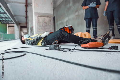 Work accident electric shock to a worker in the workplace and Unconscious lying on the floor after hand connecting power outlet to an electric tool no electrical plug.