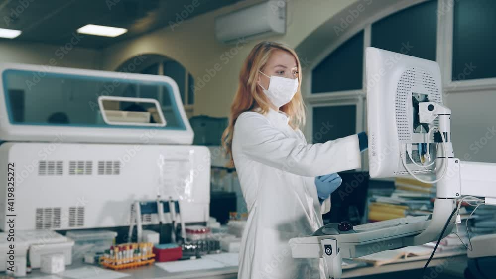 Researcher of microbiology, working in the laboratory presses the keys ...