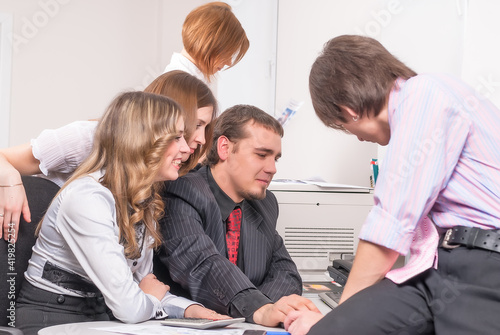 Young business team brainstorming in front of computer photo