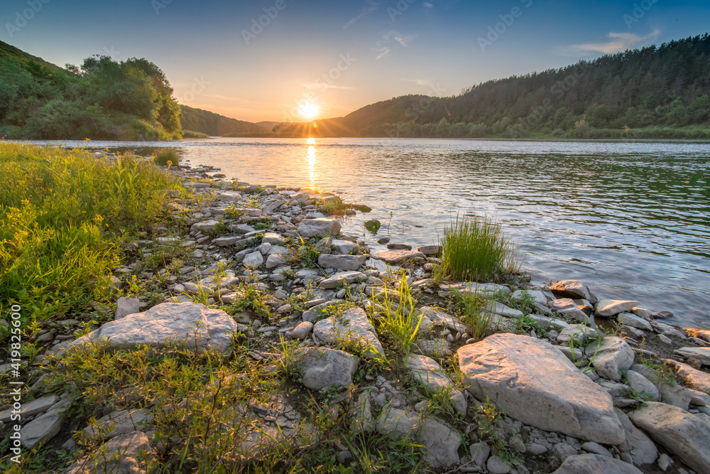 beautiful sunset overlooking the rocky bank of the river