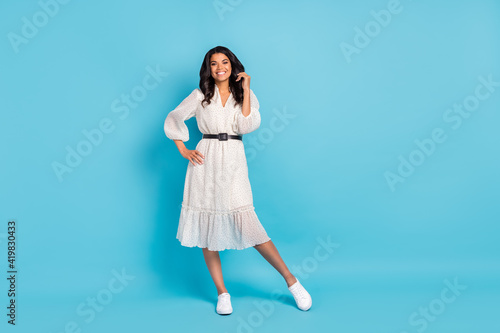 Full length body size view of attractive cheerful girl wearing cozy midi dress posing isolated over bright blue color background