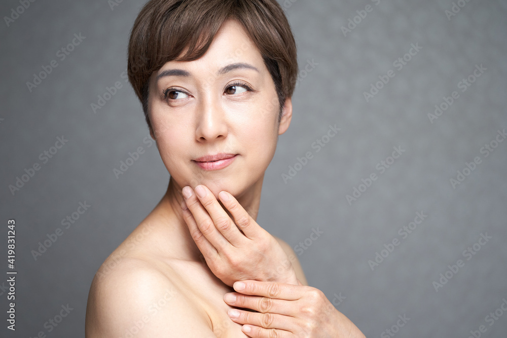 顎に手を当てる中年の日本人女性 顎に手を当てる中年の日本人女性