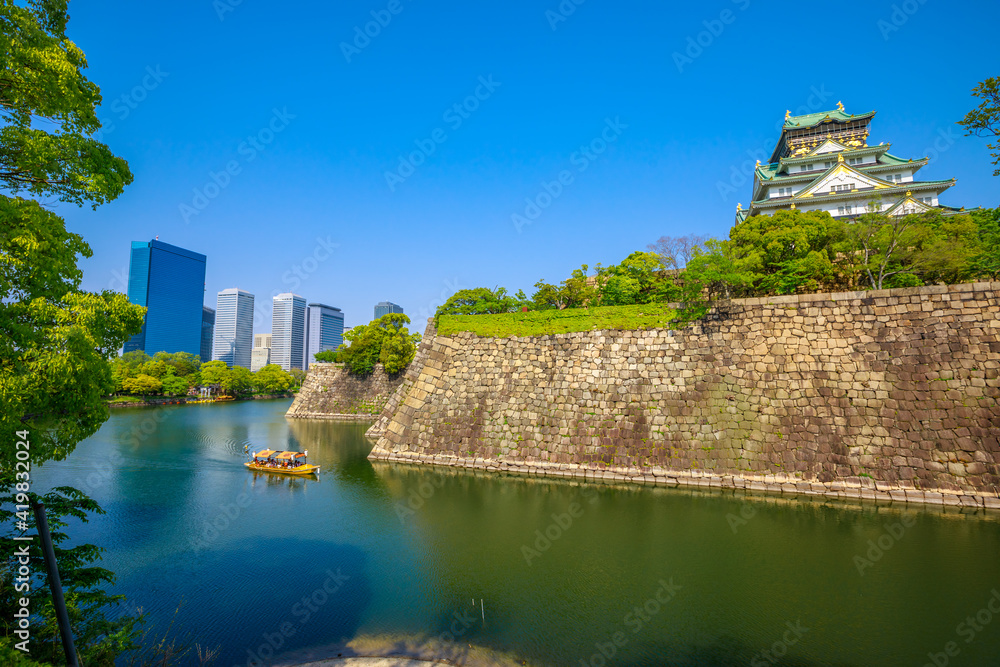 Wall and moat around Osaka Castle from Nishinomaru Garden and skyscrapers of Osaka Business Park on background. Osaka Castle is one of most famous landmarks of Japan and Osaka. Wall and moat around Osaka Castle from Nishinomaru Garden and skyscrapers of Osaka Business Park on background. Osaka Castle is one of most famous landmarks of Japan and Osaka.