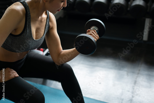 woman exercising with dumbbells, young asian girl at sport club fitness training ,group of people doing exercise, young people smiling, lifestyle women man gym sport fitness © Me studio