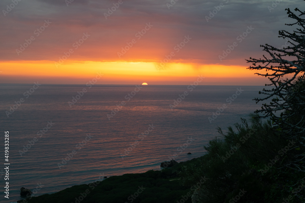 Dramatic colorful sunset read and orange sky over the Atlantic Ocean in Punta Paloma, Tarifa, Spain