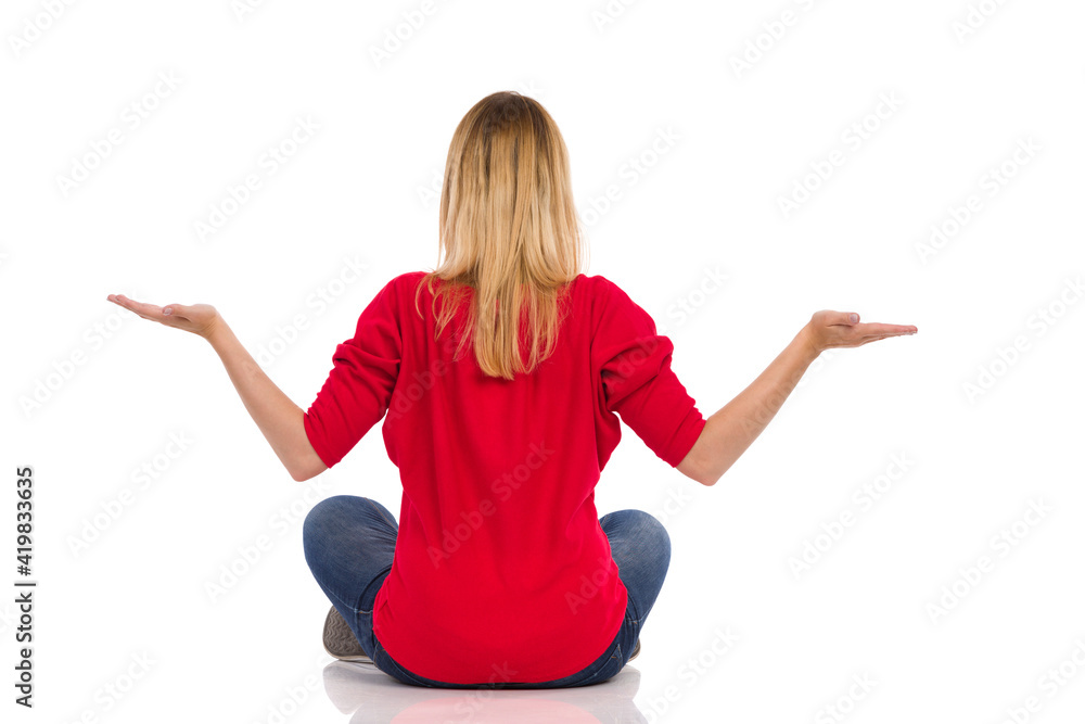 Young Woman Is Sitting On A Floor, Holding Hands Raised And Comparing. Young Woman Is Sitting On A Floor, Holding Hands Raised And Comparing.