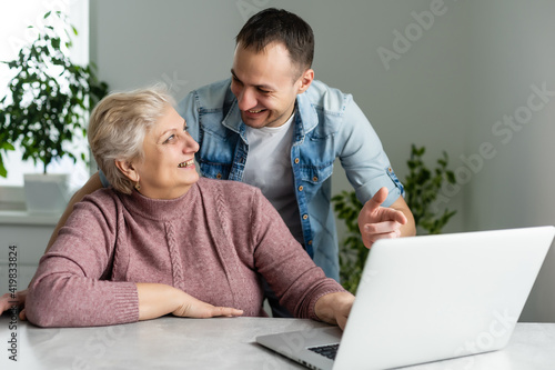 Portrait of a senior woman and a man in front of a laptop computer