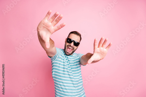 Portrait of nice cheerful content cool guy wearing sunglasses having fun dancing flirting isolated over pink pastel color background