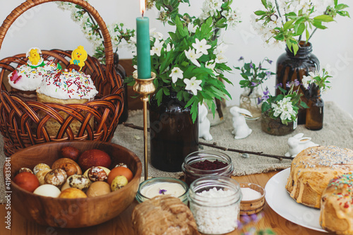 Traditional Easter food  homemade Easter bread   easter eggs and spring flowers on rustic table